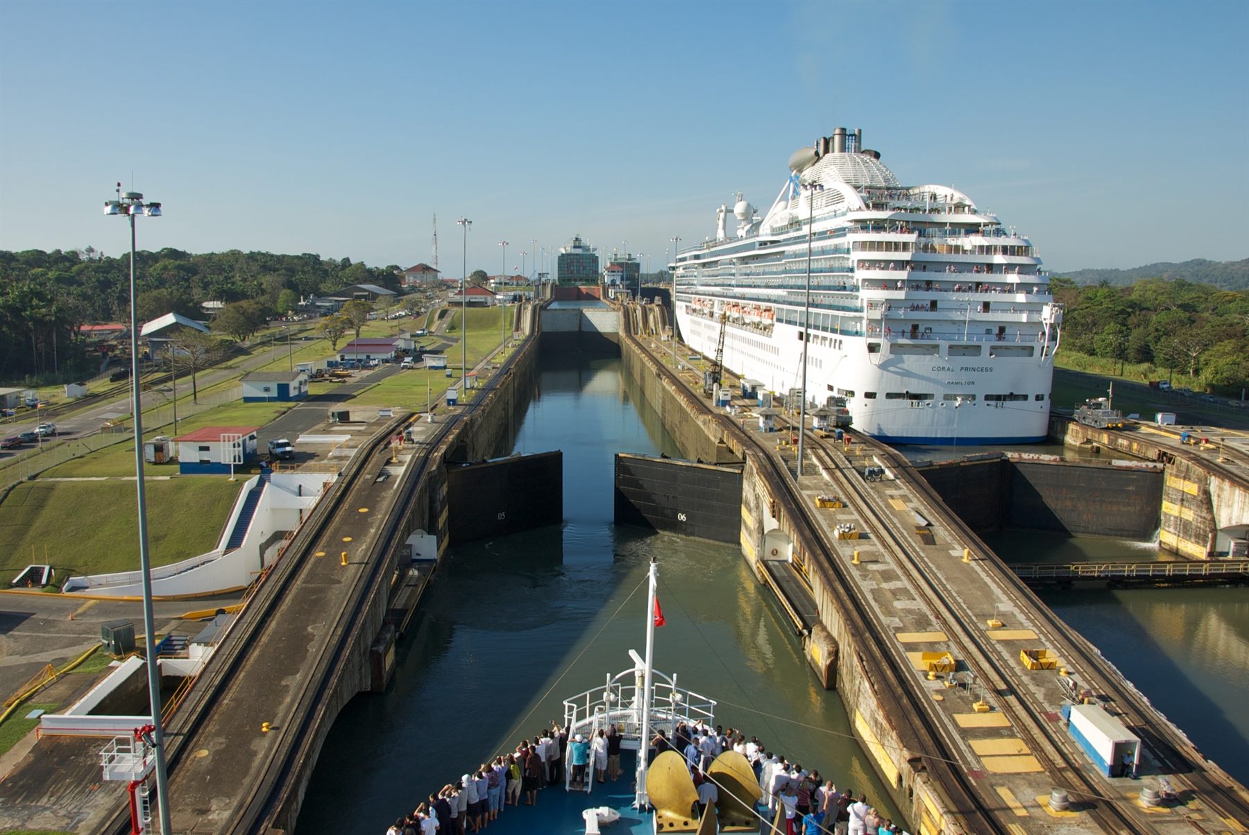 A cruise ship in a Panama Canal lock chamber, seen from another ship’s bow
